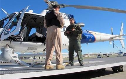 El agente Jacob Dreher (izquierda), de la Oficina del Aire y Marina de la Policía de Inmigración y Aduanas de Estados Unidos, y el agente de la Patrulla Fronteriza Mentor Cavazos muestran equipos para ayudar a inmigrantes o agentes en problemas en una oficina de la ICE en McAllen, Texas
