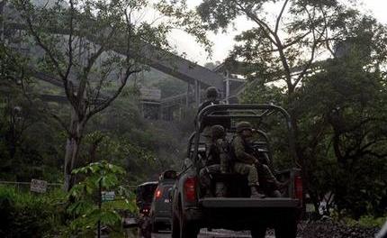 Soldados mexicanos entran en la mina de mineral de hierro en Aquila, México, el 14 de agosto del 2013. Una habitante de Aquila dijo que desde el 2012, los Caballeros Templarios han exigido de los habitantes locales parte de las regalías pagadas por una mina de hierro operada por Ternium, un consorcio con sede en Luxemburgo.