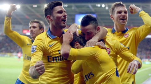 Jugadores del Arsenal rodean a Mathieu Flamini, quien ayer marcó el tercer tanto de su equipo ante el Cardiff.