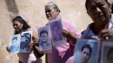 Tres mujeres sostienen retratos de sus hijos, migrantes desaparecidos, en vísperas de inciar  la novena Caravana de Madres Centroamericanas Buscando a sus Migrantes Desaparecidos en la Ruta Migratoria, en Ciudad de Guatemala.