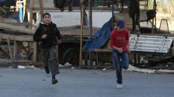 Ciudadanos corren para evitar a los francotiradores durante enfrentamientos en la frontera entre Líbano y Siria.