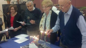 El judío Sol Feiner enciende el candelabro durante la celebración del Hanukkah.