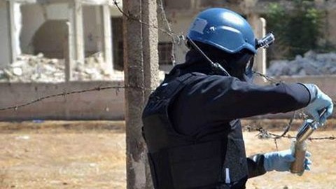 Miembros del grupo investigativo de las Naciones Unidas toman muestras de arena cerca de una zona impactada por misiles en Damasco.