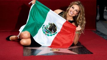 Thalía posa con la bandera mexicana durante la ceremonia en la que se develó   su estrella en el Paseo de la Fama de Hollywood y a la que acudió con su esposo.