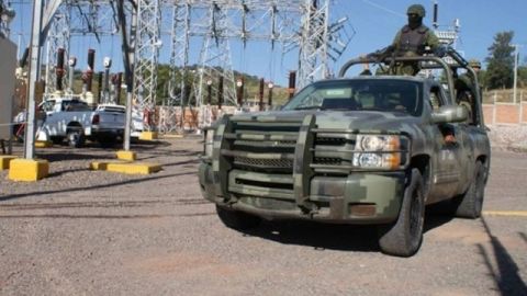 Soldados protegen a técnicos que reparan una estación de gasolina en la ciudad de Morelia, en Michoacán, que fue incendiada por presuntos narcotraficantes el 27 de octubre de 2013.