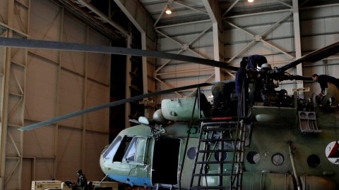 El sargento Troy Bencke (der.), de las Fuerzas Aéreas de EEUU,  señala hacia ingenieros afganos que trabajan en un Mi-17, en Kabul.