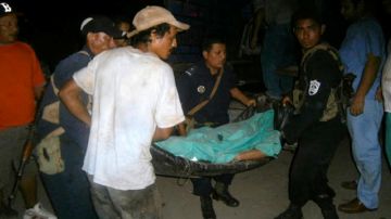 Miembros de la policía cargan el cuerpo de una víctima de la violencia en Jinotega.