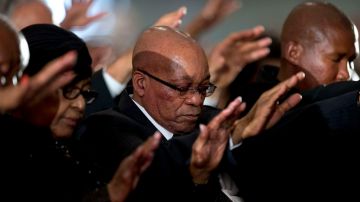 La exesposa de Nelson Mandela, Winnie Madikizela-Mandela, el presidente de Sudáfrica Jacob Zuma (centro), y el nieto de Mandela, Mandla Mandela (der.), participan en el servicio religioso este domingo en Johannesburgo.