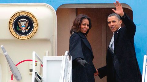 Barack Obama y su esposa Michelle abordaron el avión presidencial bajo un cielo lluvioso y frío para el largo viaje.