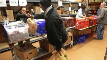 Voluntarios entregan comida a personas necesitadas en un centro de ayuda alimentaria en Chicago.