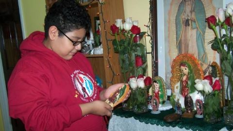 Angelito junto al colorido altar a la Virgen de Guadalupe que levantó en su casa.