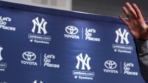 Jacoby Ellsbury (d) durante su presentación como nuevo integrante de los Yankees; a la izquierda el manager Joe Girardi.