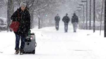 Una mujer camina sobre la nieve en Evanston, Illinois.