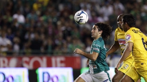 Matias Britos (izq), de León, es perseguido por los americanistas Juan Carlos Valenzuela (d) y Aquivaldo Mosquera en el primer partido de la final.