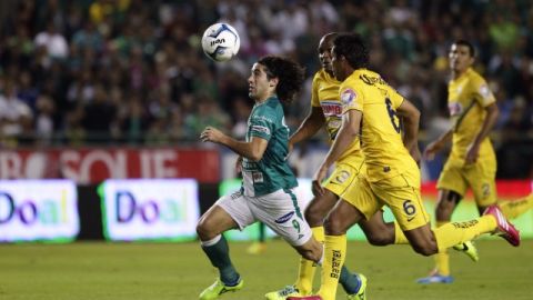 Matias Britos (izq), de León, es perseguido por los americanistas Juan Carlos Valenzuela (d) y Aquivaldo Mosquera en el primer partido de la final.