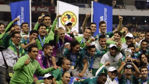Los jugadores del León bromean mientras celebran con su copa de campeones en el césped del Estadio Azteca, tras derrotar al América en el juego de vuelta de la final del Apertura 2013.