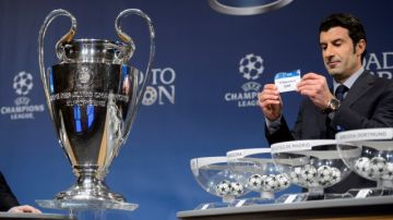 Luis Figo muestra la papeleta  del Barcelona que lo  enfrentará al Manchester City en los octavos de final de la Champions.