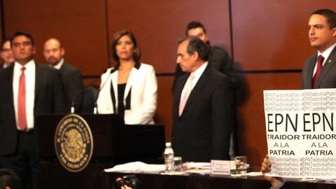Un grupo de legisladores de izquierda sostienen pancartas que leen: "EPN, traidor a la patria", mientras se declaraba constitucional la reforma energética.