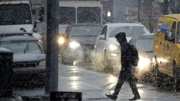 Un hombre camina bajo la nieve en NY.
