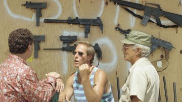 Un vendedor de armas habla con potenciales compradores en su tienda en Cutler Ridge, en Florida.