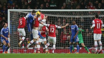 La defensa del Arsenal pasa dificultades  ante el asedio de Gary Cahill,  de Chelsea,   en un trámite del partido disputado ayer en Londres.