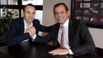 Andrés Iniesta (izq.)  y el presidente del FC Barcelona, Sandro Rosell, en el cierre del acto protocolar     que extendió el contrato del jugador.