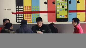 Clientes revisan varios dispositivos en una tienda de Apple en Pekín, China.