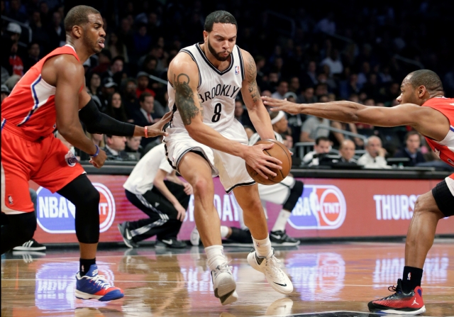Deron Williams (c), el armador de los Nets de Brooklyn, trata de avanzar ante la marca de dos defensores de los Clippers.