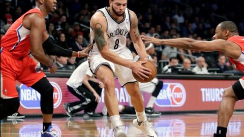 Deron Williams (c), el armador de los Nets de Brooklyn, trata de avanzar ante la marca de dos defensores de los Clippers.
