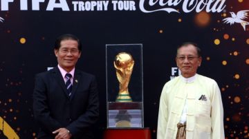 El ministro de energía de Myanmar, Nyan Tun Oo (der.), y el secretario general,  Bunny Tin Aung,  recibieron la Copa FIFA.