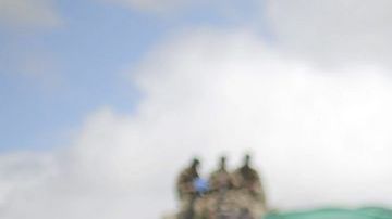 Un niño y cientos de personas observan el funeral de Nelson Mandela en una exhibición pública en su villa de Qunu, Sudáfrica.