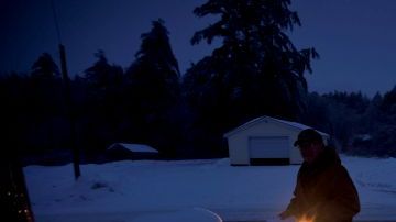 Jim Ridley usa una linterna pararecoger su correo, en Litchfield, Maine, donde ha estado sin electricidad desde la tormenta de hielo del lunes.