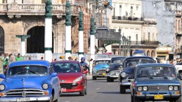 Varios autos circulan por una de las calles centricas de La Habana.