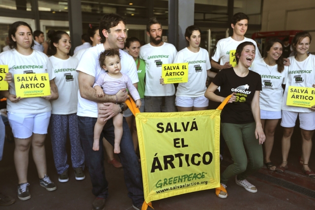 Los activistas argentinos de Greenpeace Camila Speziale, (frente-d) y Hernán Pérez Orsi (frente-i) posan con miembros de Greenpeace después de arribar al Aeropuerto Internacional Ministro Pistarini en Buenos Aires.