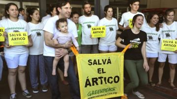 Los activistas argentinos de Greenpeace Camila Speziale, (frente-d) y Hernán Pérez Orsi (frente-i) posan con miembros de Greenpeace después de arribar al Aeropuerto Internacional Ministro Pistarini en Buenos Aires.