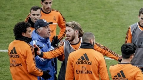 El técnico del Real Madrid, Carlo Ancelotti, rodeado de jugadores durante el último entrenamiento de 2013 del equipo celebrado hoy al calor de sus aficionados en el estadio Alfredo Di Stéfano que registró un lleno en sus gradas