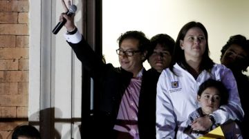Gustavo Petro (i), aluda a sus seguidores desde un balcón  en Bogotá.