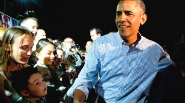 El presidente Barack Obama saluda a simpatizantes antes de abordar el avión presidencial Air Force One en el aeropuerto de Honolulu el sábado en la noche.