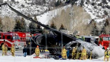 Personal de emergencias trabaja cerca de un avión de pasajeros que se estrelló al aterrizar en el aeropuerto del condado Aspen-Pitkin, en Aspen, Colorado, el domingo 5 de enero de 2014.