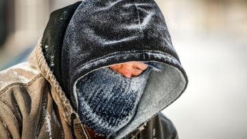 El residente de Illinois, Bill Brasche, camina por una calle de Springfield mientras el hielo cubre su ropa y su rostro, debido a las extremas bajas temperaturas.