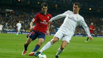 El portugués Cristiano Ronaldo, del Real Madrid, disputa el esférico con Alejandro Arribas, del Osasuna