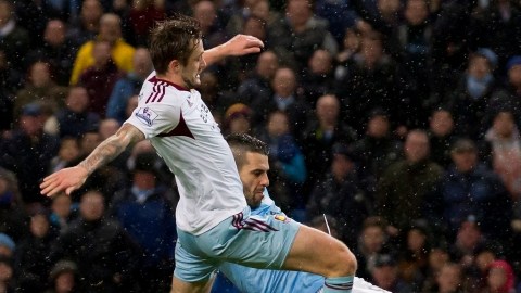 Álvaro Negredo (der.) anticipa el cierre del defensor George McCartney de West Ham, para anotar el segundo de su triplete ayer en Manchester.
