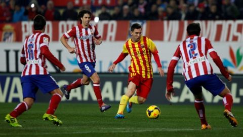 Lionel Messi controla el balón entre tres jugadores del Atlético del Madrid que ayer se efectuó en el Estadio Vicente Calderón.