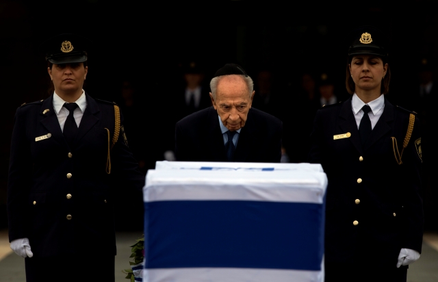 El presidente israelí Shimon Peres rinde tributo ante el ataúd del exprimer ministro Ariel Sharon, ayer en el Parlamento, en Jerusalén.