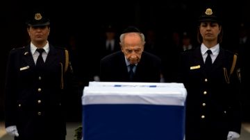 El presidente israelí Shimon Peres rinde tributo ante el ataúd del exprimer ministro Ariel Sharon, ayer en el Parlamento, en Jerusalén.