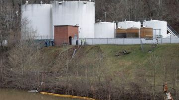 Trabajadores inspeccionan el lunes, 14 de enero, una zona fuera de un muro de contención alrededor de los tanques de almacenamiento de Freedom Industries, donde se derramó una sustancia química al río Elk.