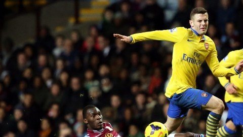Jack Wilshere (centro) supera en la acción a   Christian Benteke  durante el partido por la Liga Premier, jugado en  Villa Park en Birmingham.
