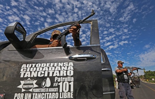 Integrantes de grupos de autodefensa durante enfrentamientos con comandos armados en la población de Nueva Italia en el estado mexicano de Michoacán. Los ataques se vienen registrando desde el sábado.