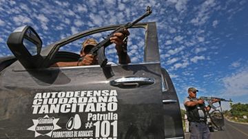 Integrantes de grupos de autodefensa durante enfrentamientos con comandos armados en la población de Nueva Italia en el estado mexicano de Michoacán. Los ataques se vienen registrando desde el sábado.