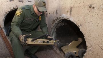 El agente de la Patrulla Fronteriza de Tucson, Ryan Grimm, revisa un control remoto antes de enviarlo a rastrear túneles en la frontera con México.